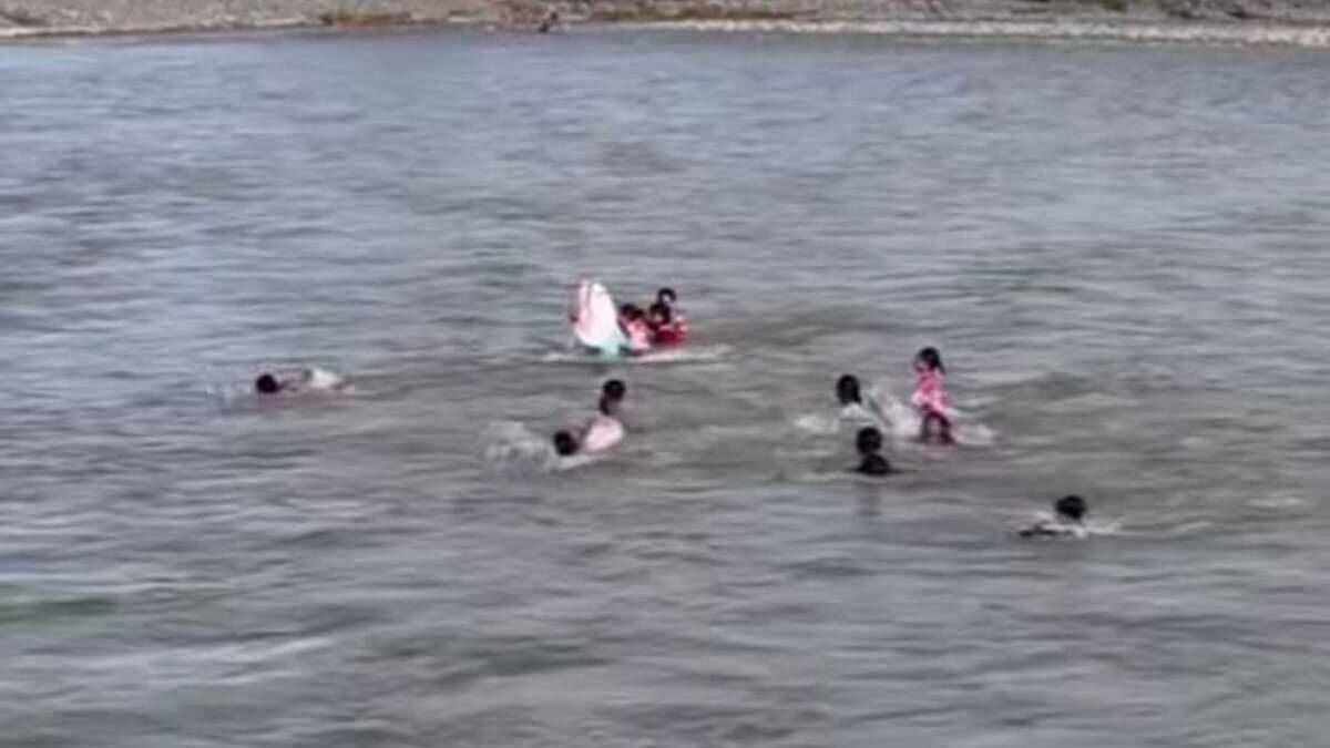 Indonesian children in West Aceh swim across river after bridge destroyed by floods seven months ago